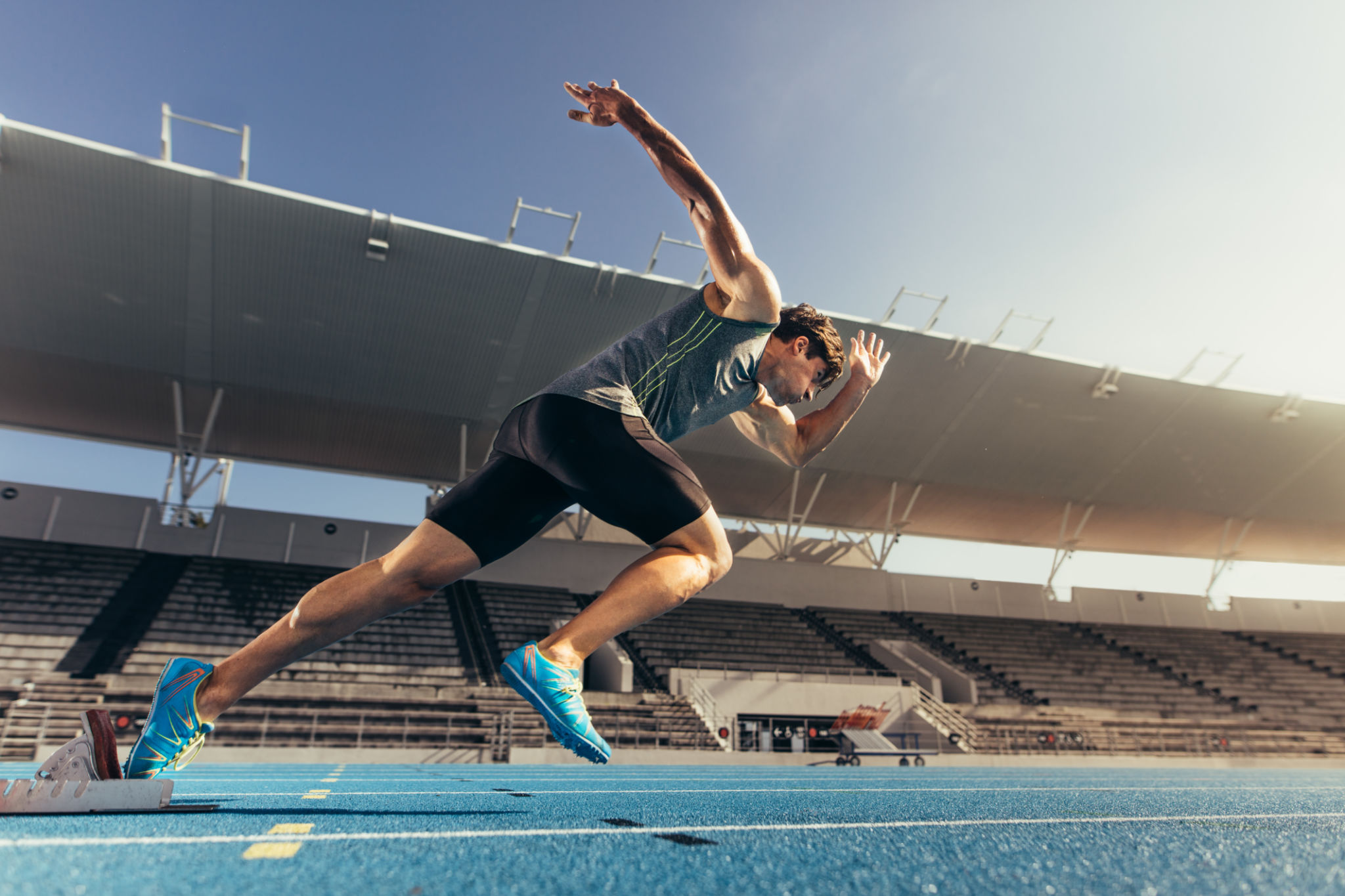Athlete sprinting off the starting block on a track