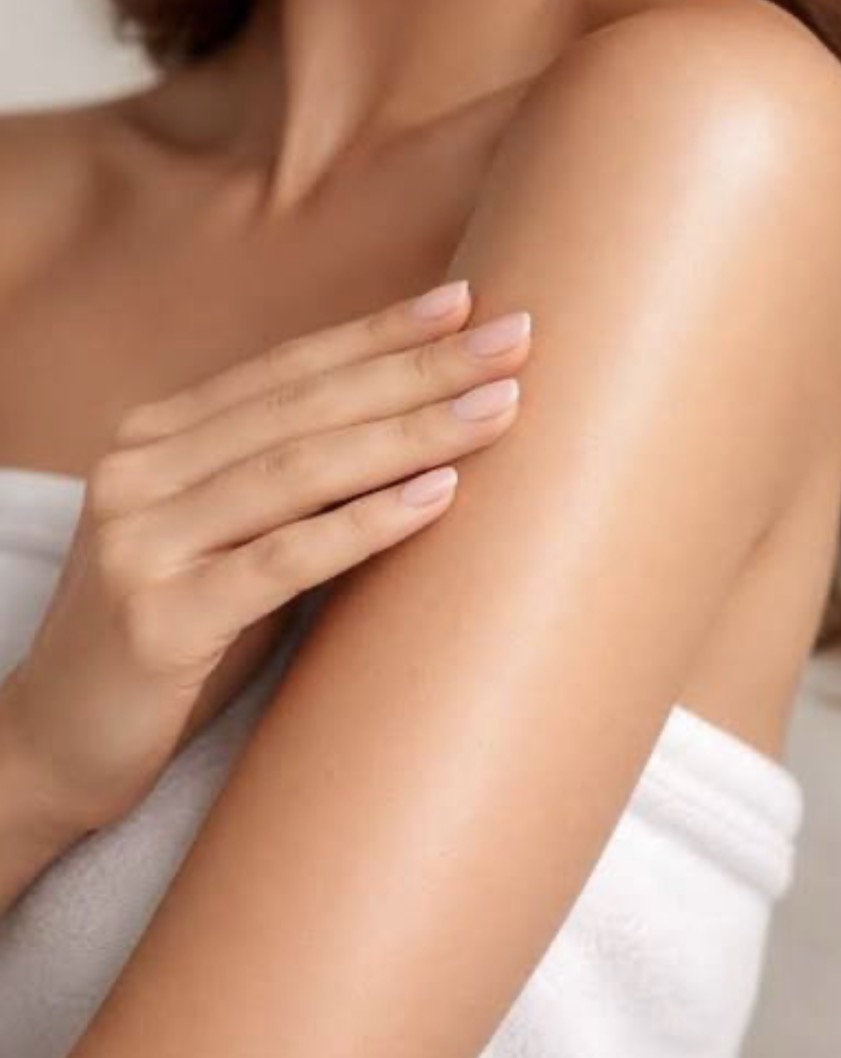 Woman with smooth glowing skin touching her arm